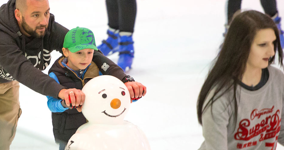 Image of a young boy and a man ice skating.