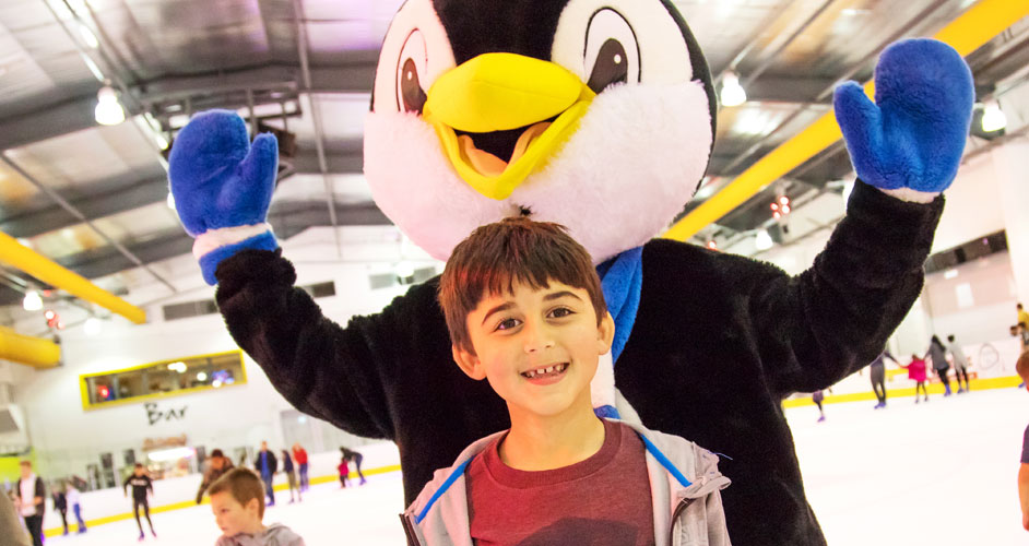 Image of a boy on the ice with a mascot